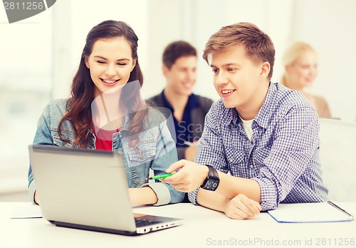 Image of students with laptop and notebooks at school