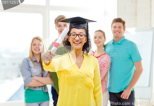 Image of smiling female student with diploma and corner-cap