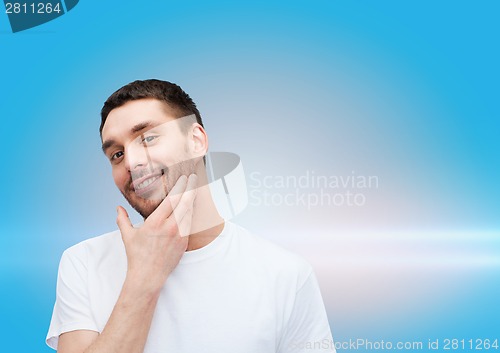 Image of beautiful smiling man touching his face