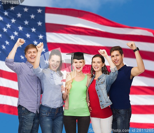 Image of group of standing smiling students with diploma