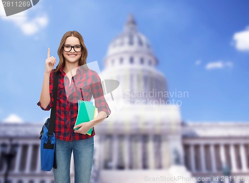 Image of smiling female student with bag and notebooks