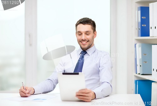Image of smiling businessman with tablet pc and documents