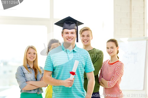 Image of smiling male student with diploma and corner-cap