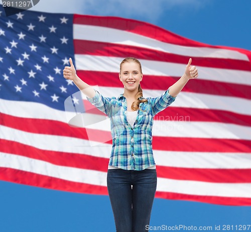 Image of smiling girl in casual clothes showing thumbs up