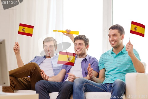 Image of happy male friends with flags and vuvuzela