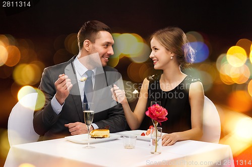 Image of smiling couple eating dessert at restaurant