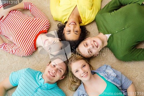 Image of group of smiling people lying down on floor