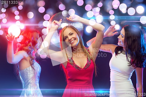 Image of three smiling women dancing in the club