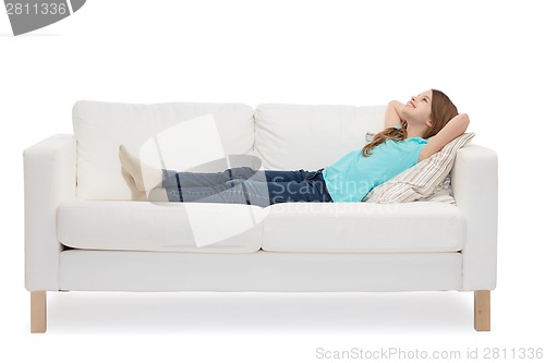 Image of smiling little girl lying on sofa