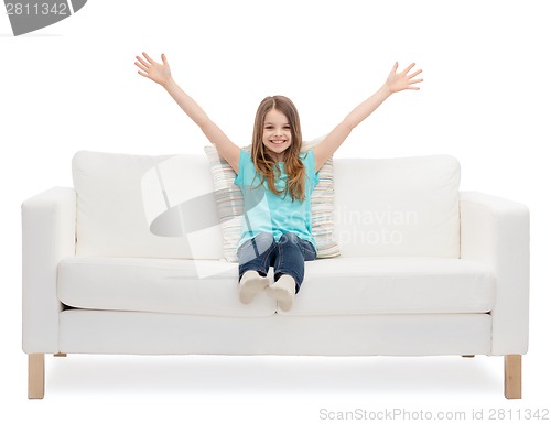 Image of little girl sitting on sofa and waving hands