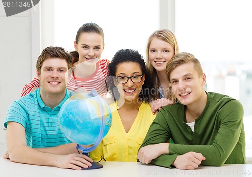 Image of five smiling student with earth globe at school