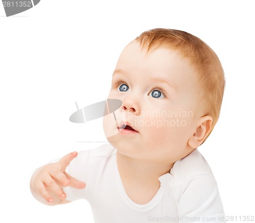 Image of curious baby lying on floor and looking up