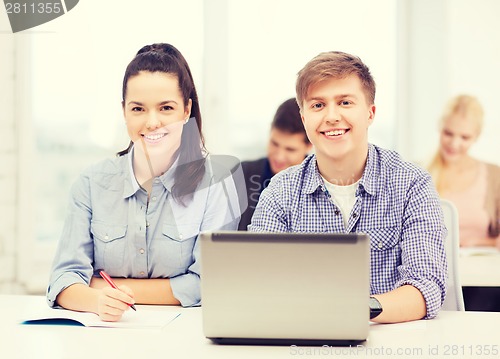 Image of students with laptop and notebooks at school