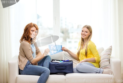 Image of two smiling teenage girls with plane tickets