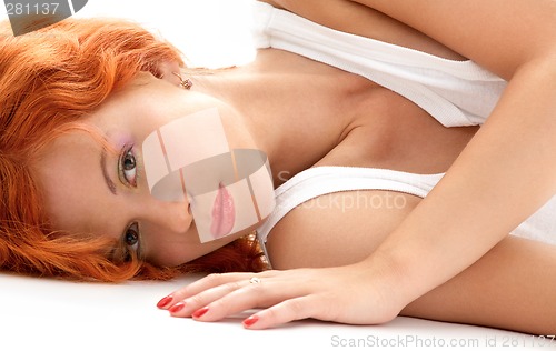 Image of laying redhead in white shirt