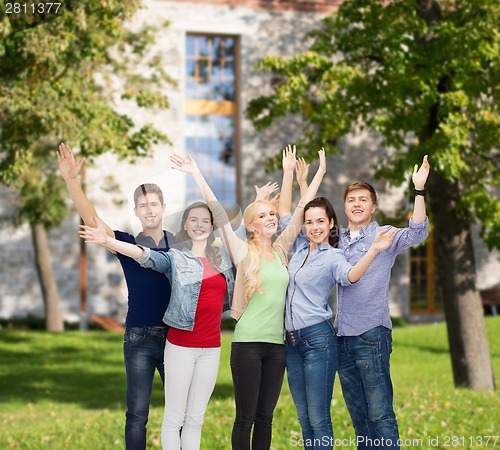 Image of group of smiling students waving hands