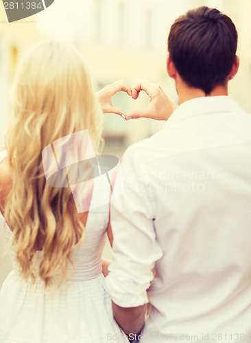 Image of romantic couple in the city making heart shape