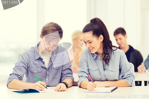 Image of two teenagers with notebooks at school