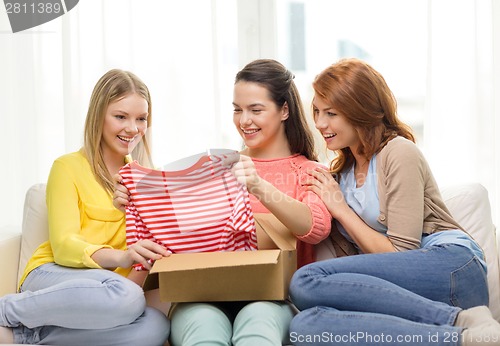 Image of smiling teenage girls opening cardboard box