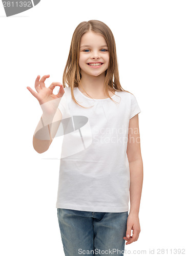 Image of little girl in white t-shirt showing ok gesture