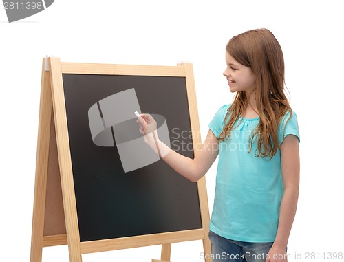 Image of happy little girl with blackboard and chalk