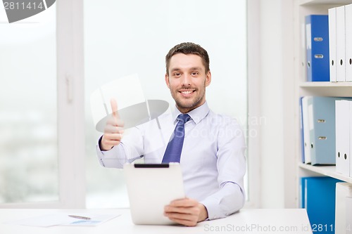 Image of smiling businessman with tablet pc and documents