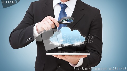 Image of businessman hand holding magnifier over tablet pc