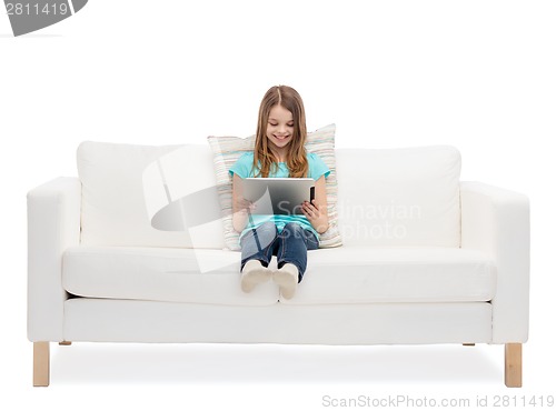 Image of little girl sitting on sofa with tablet pc comuter