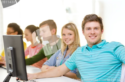 Image of male student with classmates in computer class