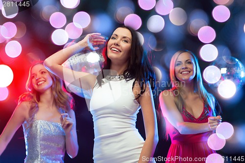 Image of three smiling women dancing in the club