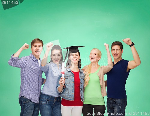 Image of group of standing smiling students with diploma