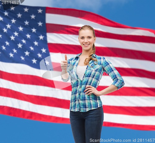 Image of young woman in casual clothes showing thumbs up