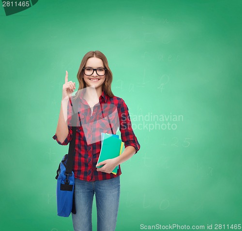 Image of smiling female student with bag and notebooks