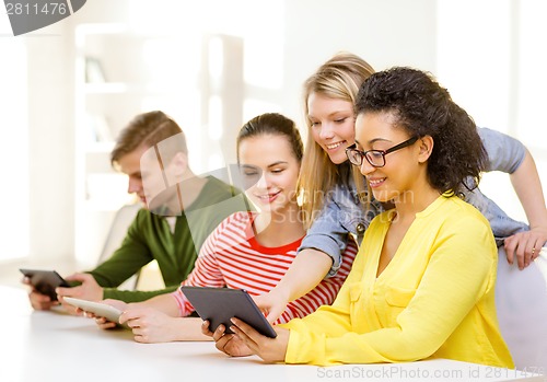 Image of smiling students looking at tablet pc at school