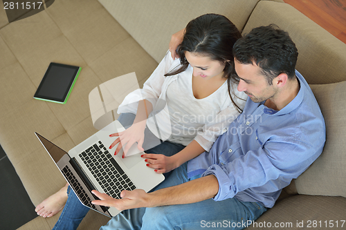 Image of young couple using laptop at home