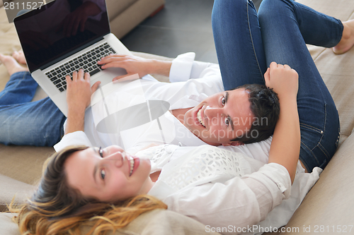 Image of young couple using laptop at home