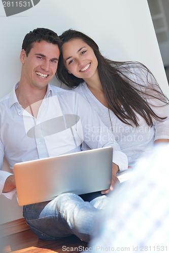 Image of young couple using laptop at home