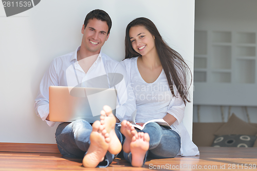 Image of young couple using laptop at home