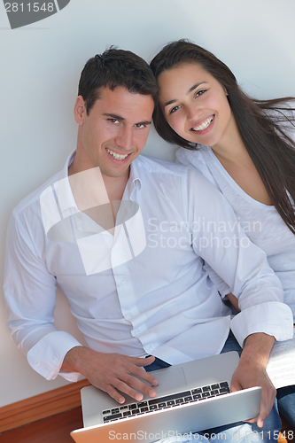 Image of young couple using laptop at home