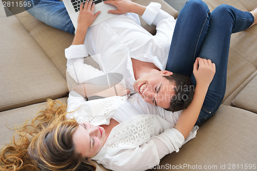 Image of young couple using laptop at home