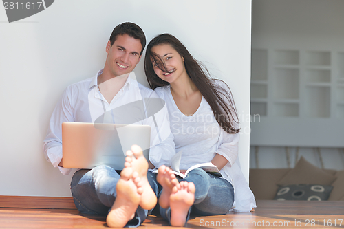 Image of young couple using laptop at home