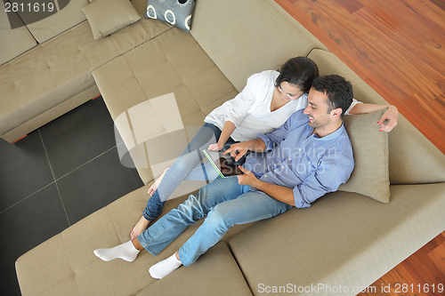 Image of couple at home using tablet computer