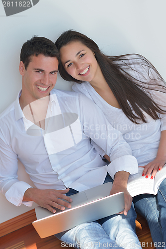 Image of young couple using laptop at home