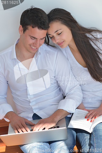 Image of young couple using laptop at home