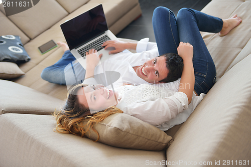 Image of young couple using laptop at home
