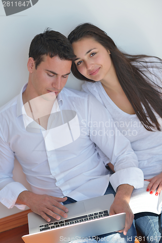 Image of young couple using laptop at home