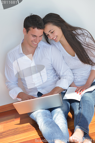 Image of young couple using laptop at home