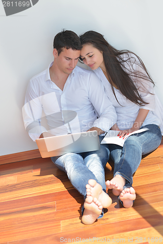 Image of young couple using laptop at home