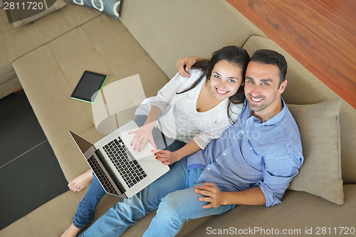 Image of young couple using laptop at home