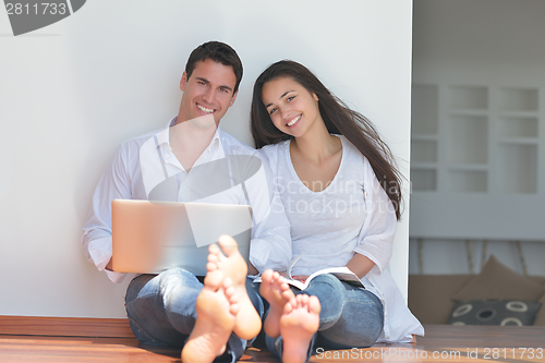 Image of young couple using laptop at home